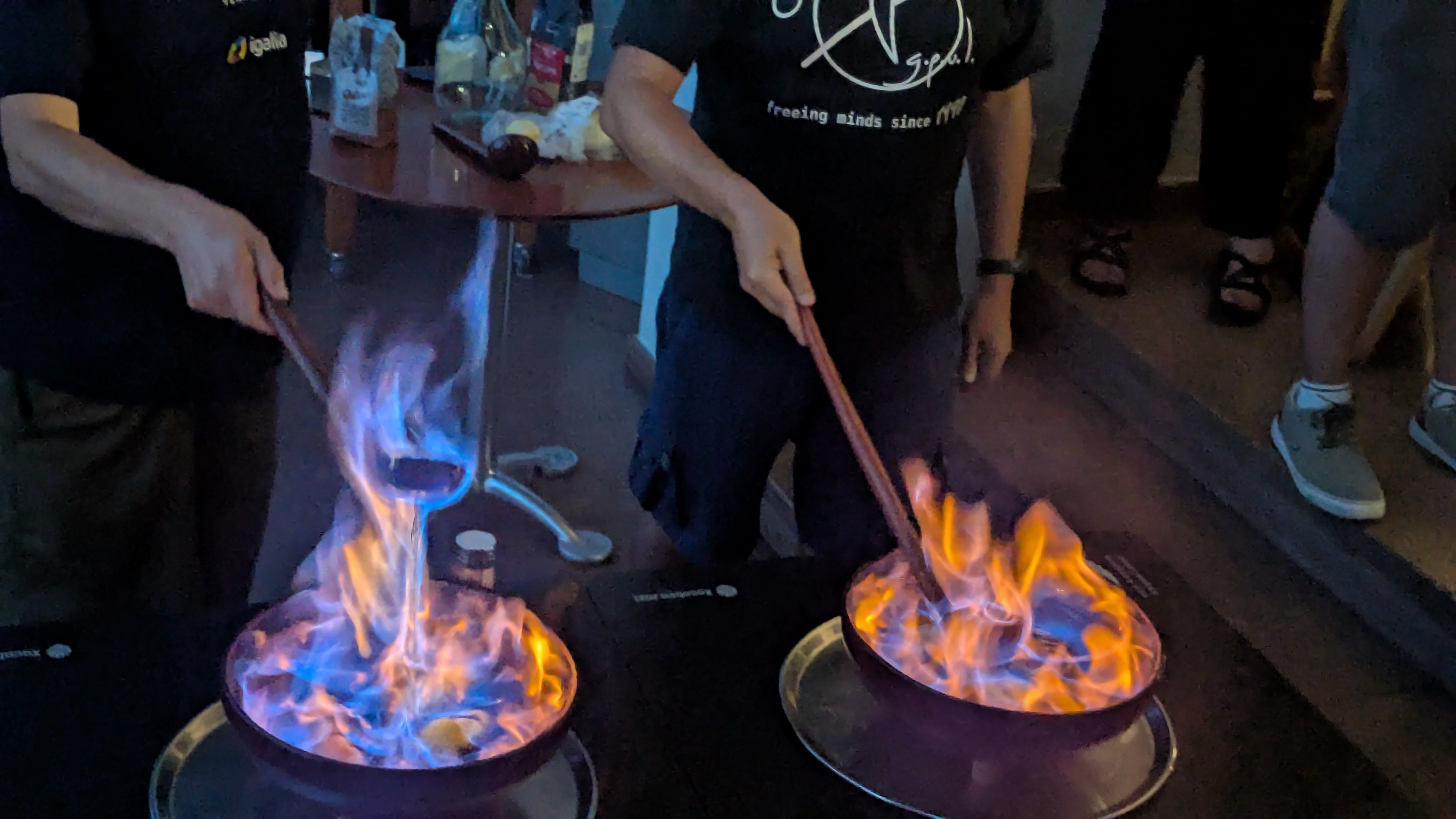 Two pots of Queimada during the phase of burning the alcohol, while someone recites a incantation in the background.